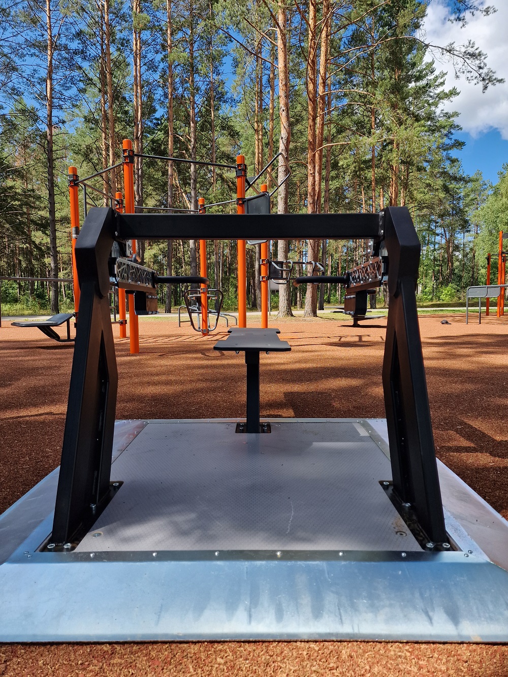 Die Abb. zeigt das Outdoor Kraftgerät Bankdrücken Alpha Steel mit abweichender Bodenplatte.