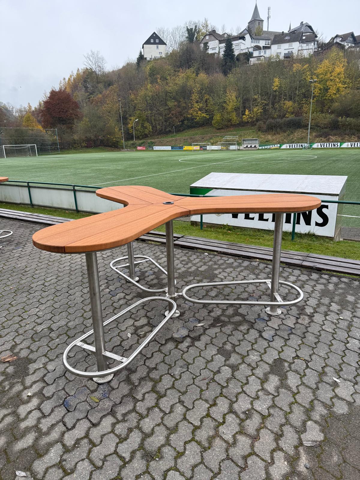 Die Abb. zeigt den Boomerang Stehtisch montiert im Freien.